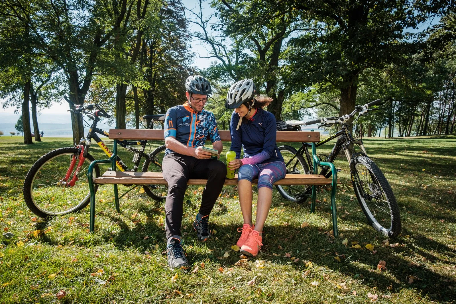 Pár cyklistů odpočívá na lavičce